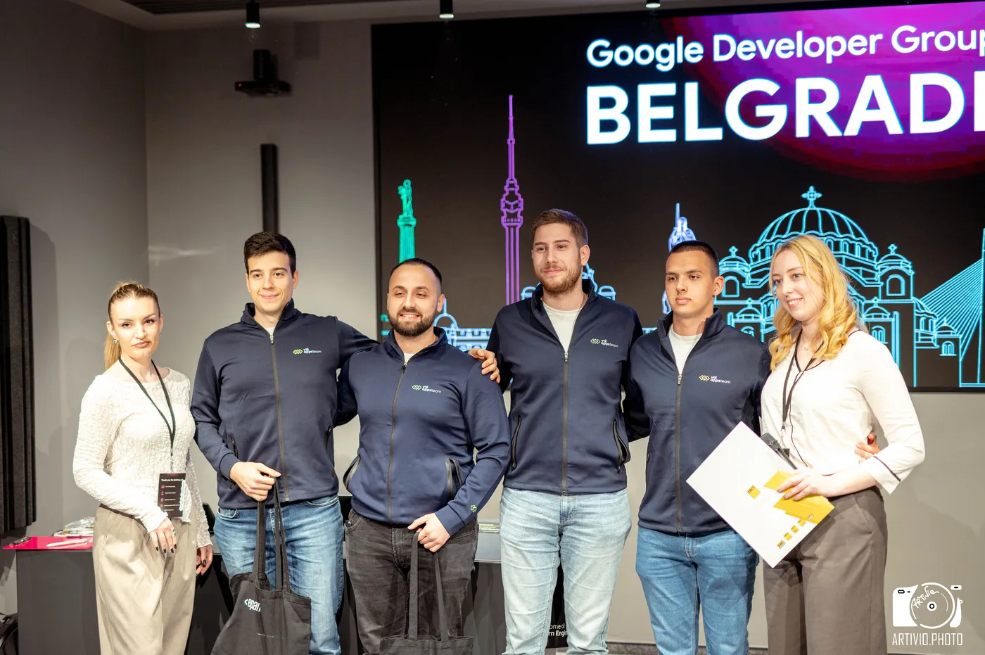 Tim u timskim duksevima ispred ekrana Google Developer Group Belgrade na Build with AI hakatonu 2026.